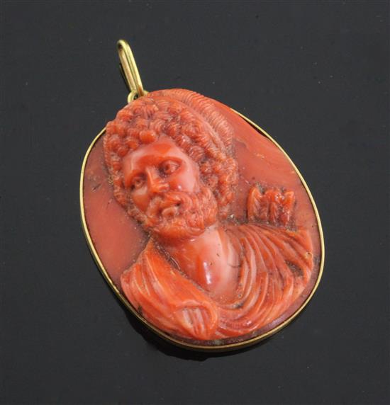 An antique Italian gold mounted oval coral cameo pendant, carved with the bust of a bearded archer, 41mm.